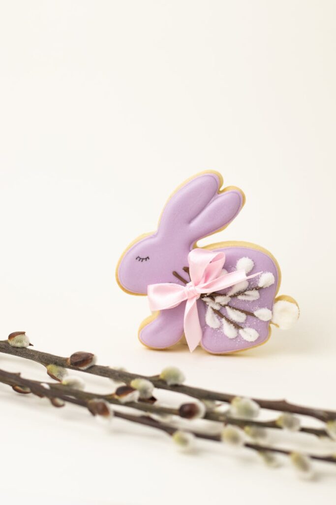 Adorable purple bunny cookie with pink bow and willow twigs for Easter decor.