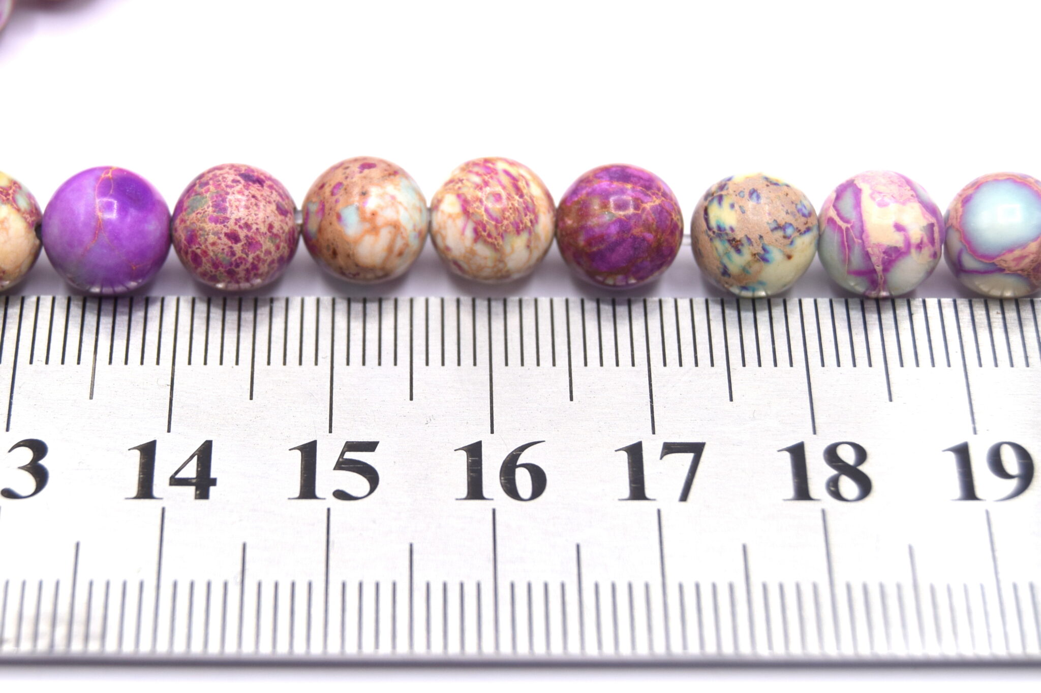 perles-jaspe-imperial-ronde-naturel-teinte-bleu-violet-8mm taille devant une règle